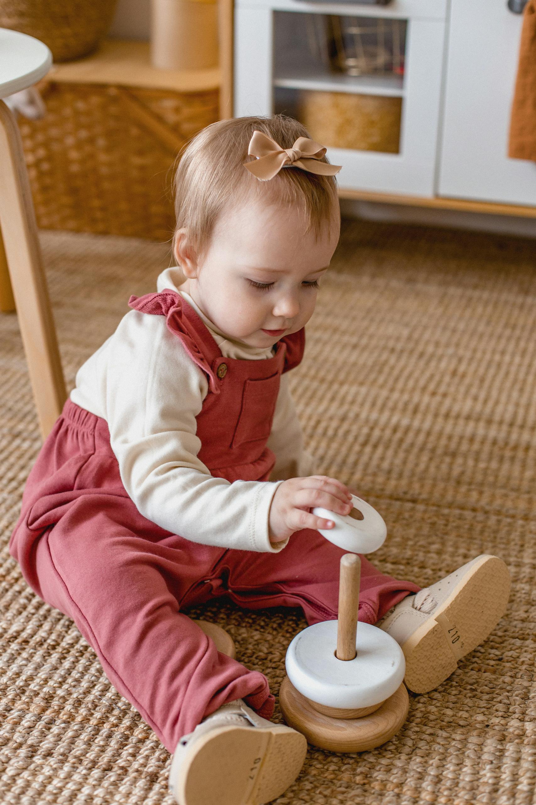 A baby playing with a wooden toy