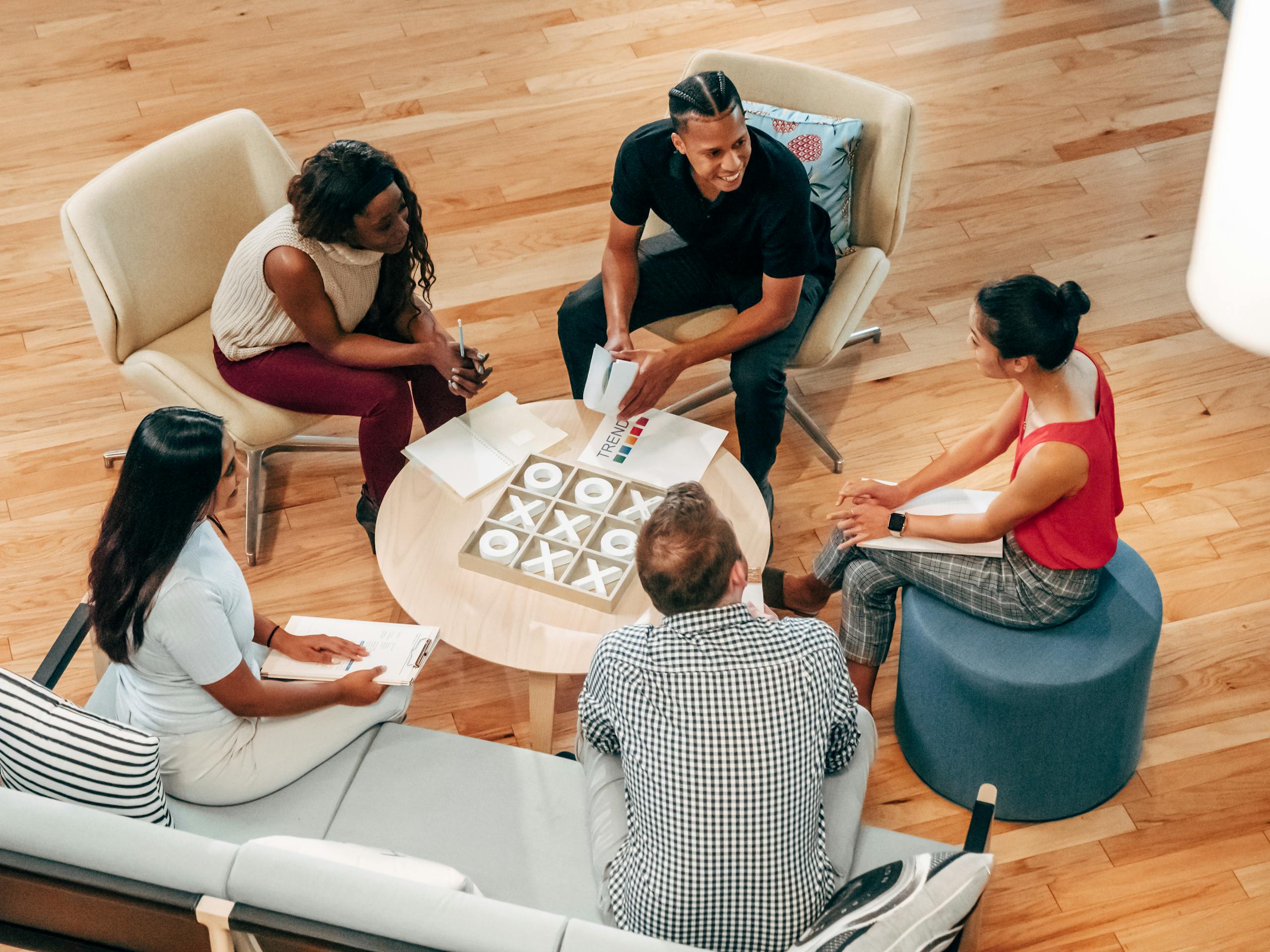 A group of diverse coworkers engaged in a collaborative meeting in a modern indoor office setting.