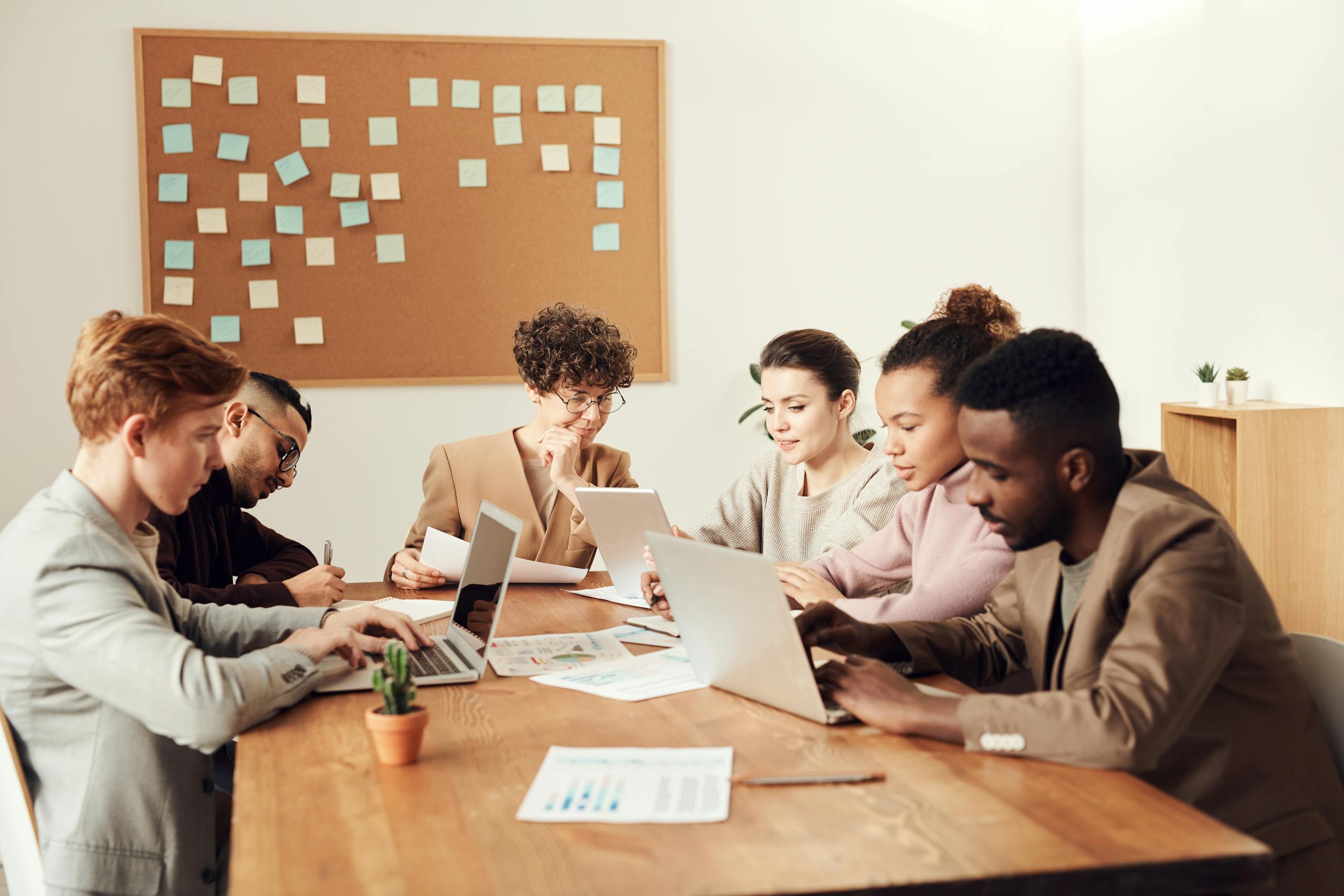 A group of professionals collaborating on laptops in a modern office space, focusing on teamwork.